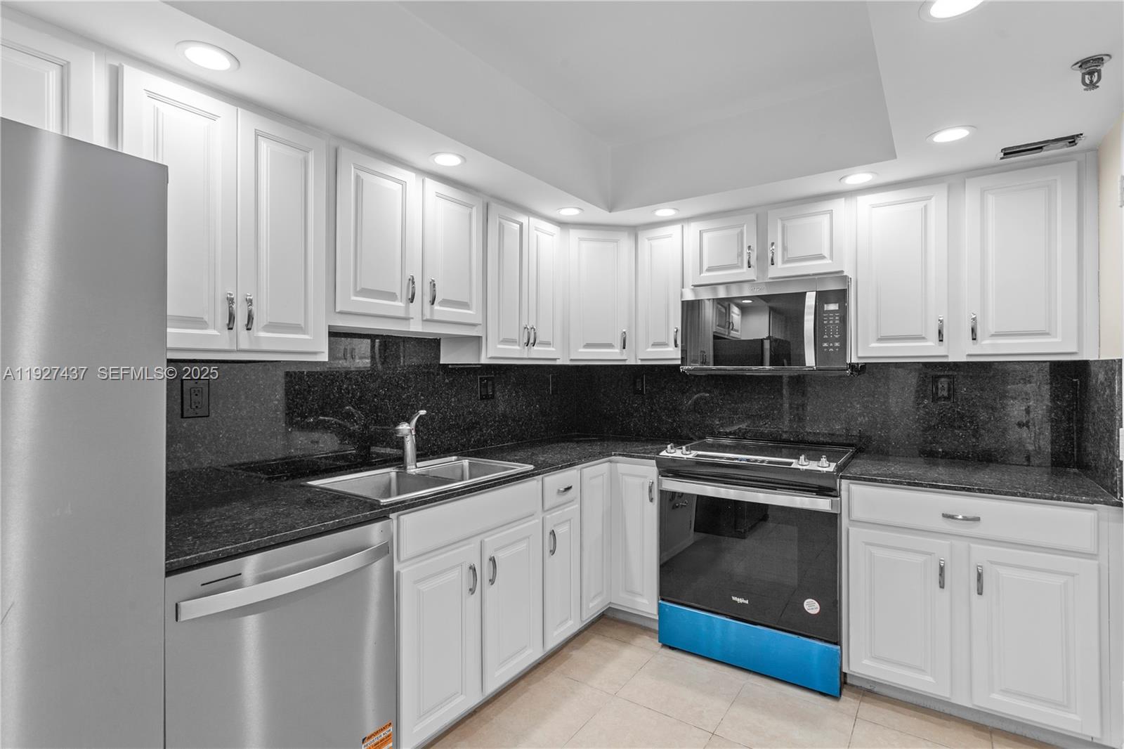 9511 Collins Avenue, Unit 806 Surfside, FL 33154 - Photo 6 of 32 a kitchen with appliances a sink and cabinets