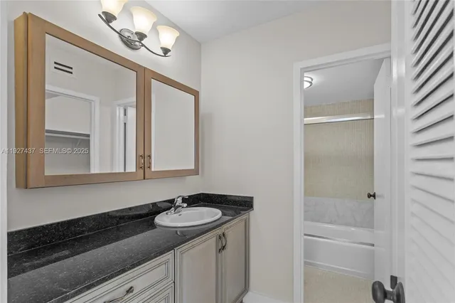 a bathroom with a sink a light fixture and a mirror