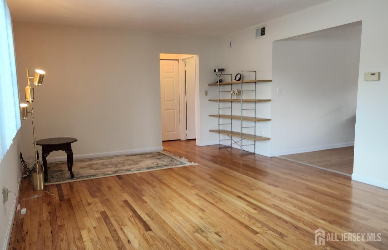 182 Evergreen Road, Unit 3A Edison, NJ 08837 - Photo 2 of 13 a view of empty room with wooden floor and fan