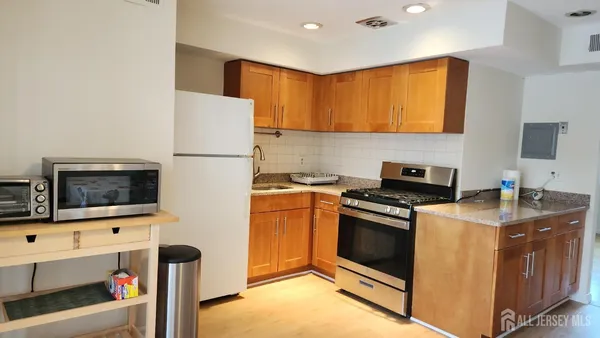 a kitchen with stainless steel appliances a stove a microwave a sink and a refrigerator