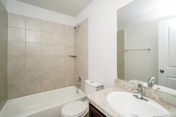 a bathroom with a granite countertop sink toilet and bathtub