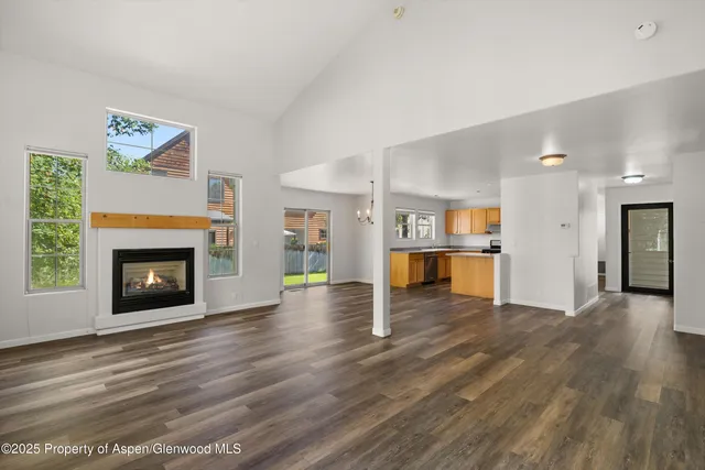 a view of empty room with wooden floor and fireplace