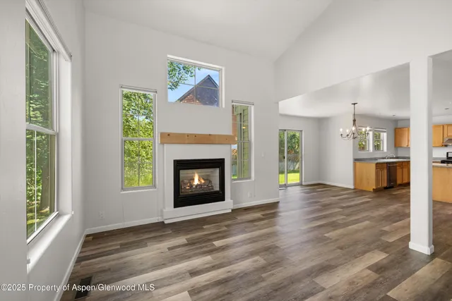 a view of an empty room with a window and fireplace