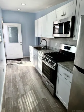 a kitchen with granite countertop a stove and a microwave