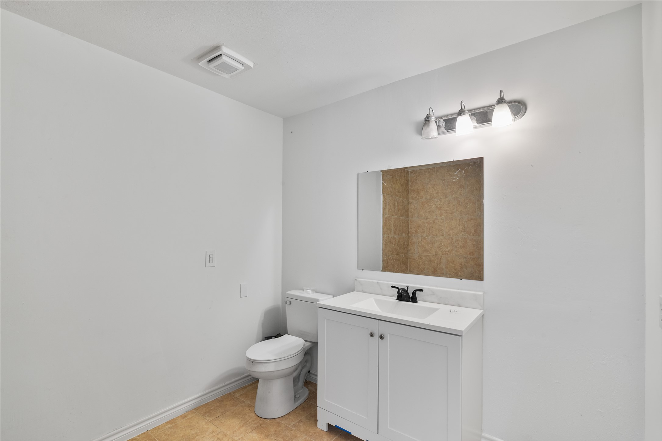 36622 Tompkins Road Hempstead, TX 77445 - Photo 29 of 46 a bathroom with a toilet a sink a mirror and vanity