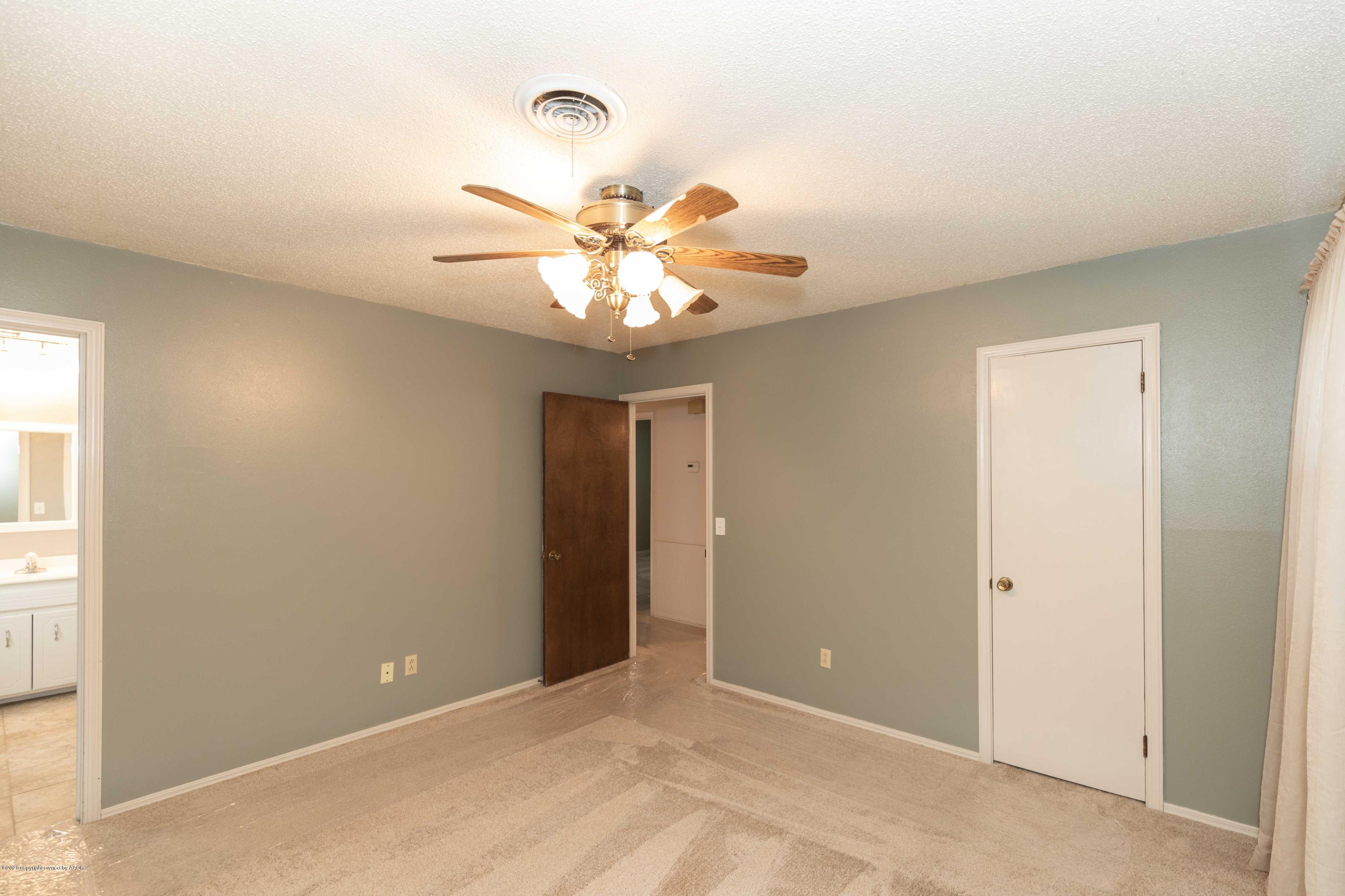4924 South Georgia Street Amarillo, TX 79110 - Photo 18 of 35 an empty room with a chandelier fan and windows