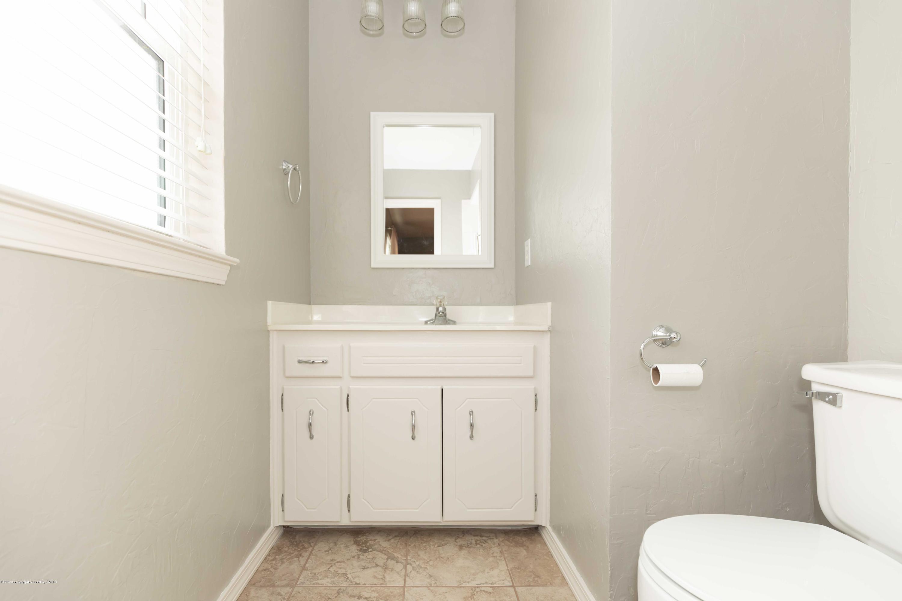4924 South Georgia Street Amarillo, TX 79110 - Photo 20 of 35 a bathroom with a sink a toilet and a window