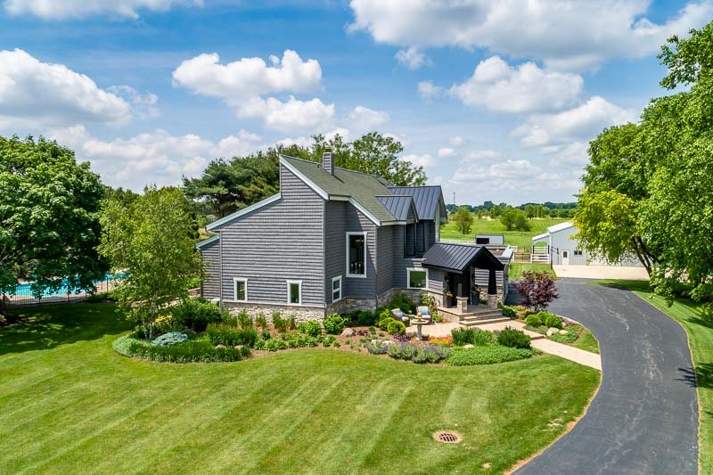 10762 Shaw Road Rockford, IL 61114 - Photo 1 of 25 a front view of a house with garden and swimming pool