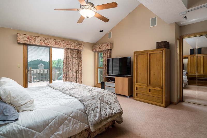 10762 Shaw Road Rockford, IL 61114 - Photo 23 of 25 a bedroom with a bed flat screen tv and a large window