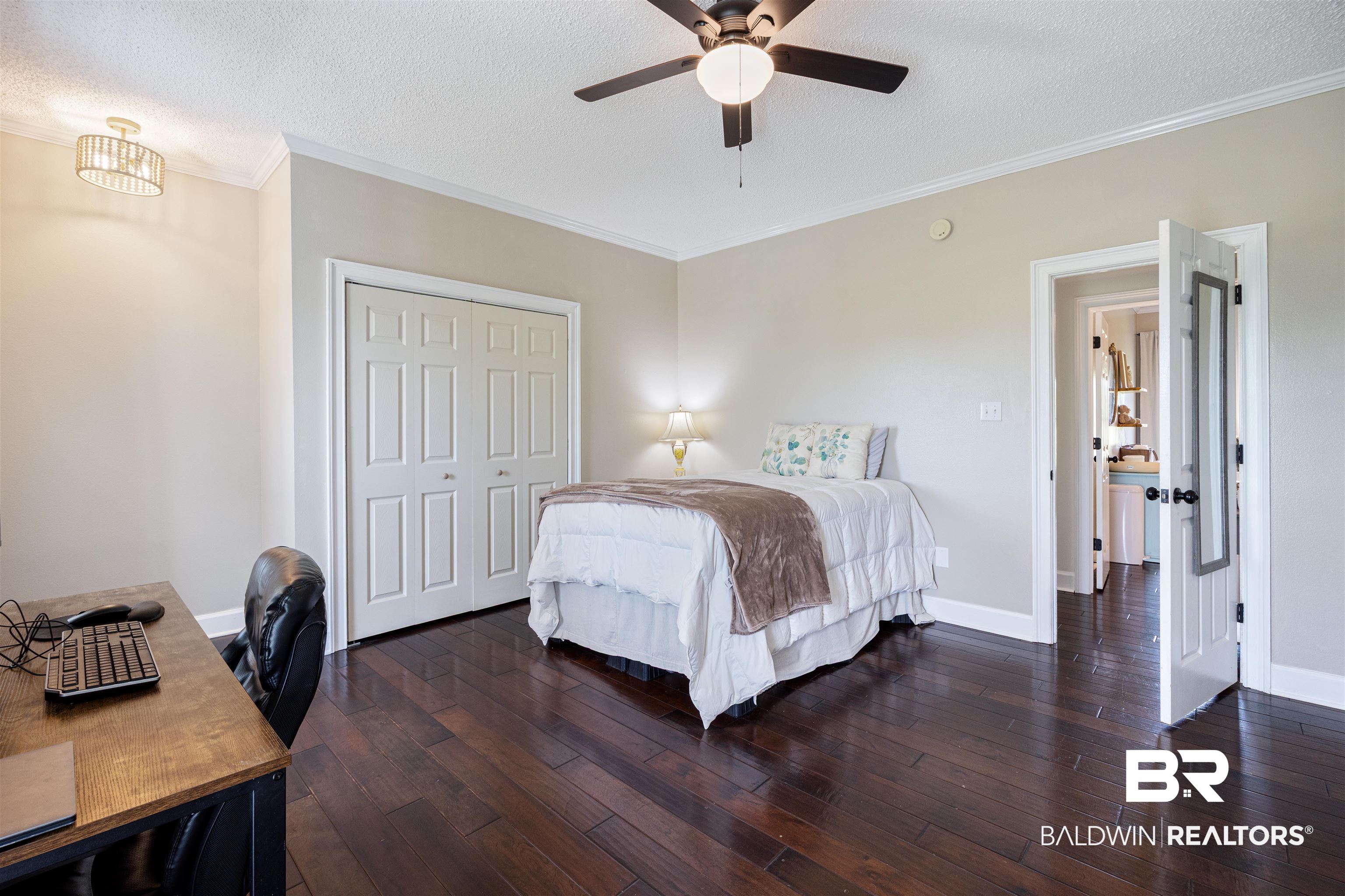 9855 Stucki Road Elberta, AL 36530 - Photo 43 of 54 Bedroom featuring ornamental molding, a desk, a closet, dark wood finished floors, and a ceiling fan