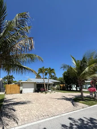a view of a house with a yard and potted plants