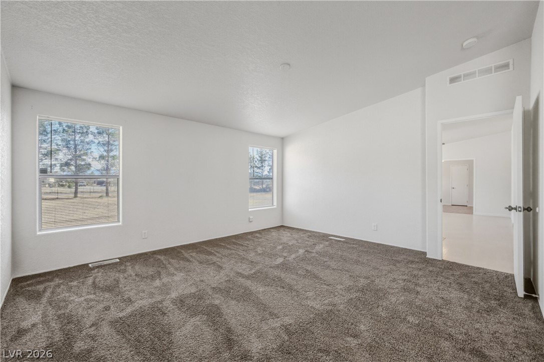 1890 West Dyer Road Pahrump, NV 89048 - Photo 14 of 40 This spacious bedroom offers ample natural light and a clean, comfortable aesthetic.