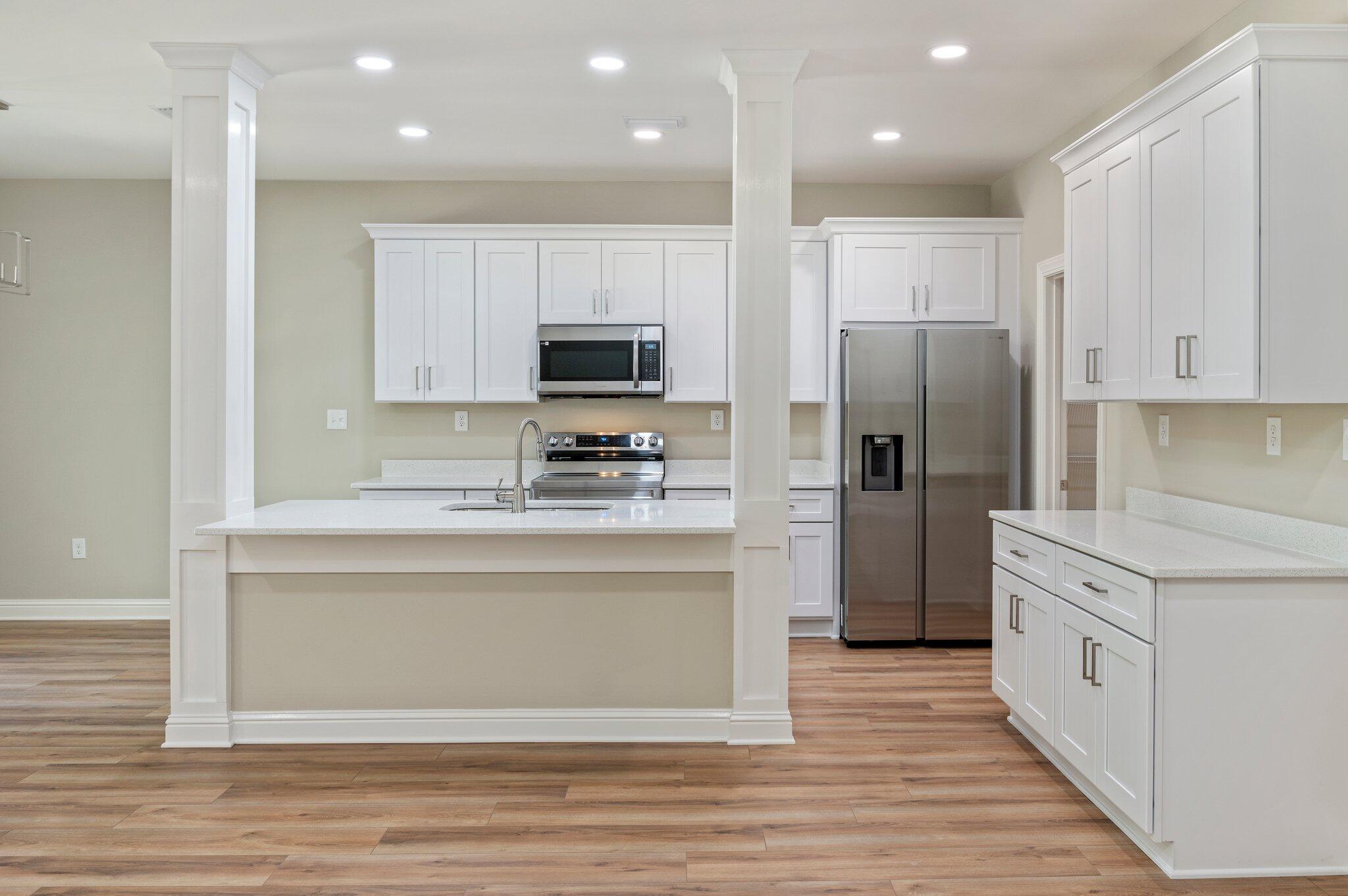 6043 Sand Hill Road Crestview, FL 32539 - Photo 12 of 36 a kitchen with kitchen island granite countertop a refrigerator and a stove top oven