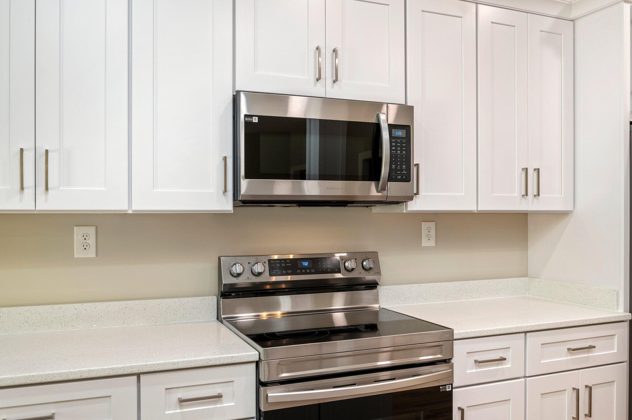 6043 Sand Hill Road Crestview, FL 32539 - Photo 14 of 36 a kitchen with granite countertop white cabinets and stainless steel appliances