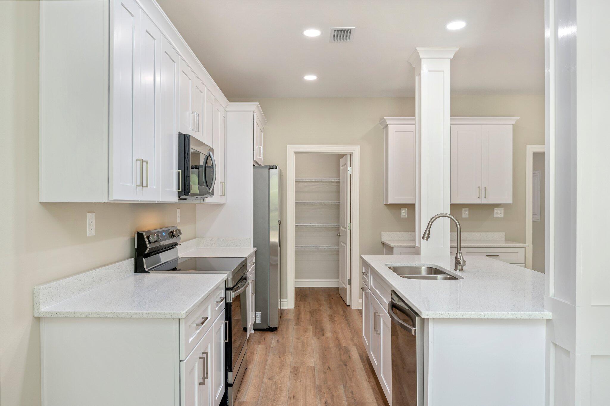 6043 Sand Hill Road Crestview, FL 32539 - Photo 15 of 36 a kitchen with stainless steel appliances a sink a stove a refrigerator a center island and cabinets