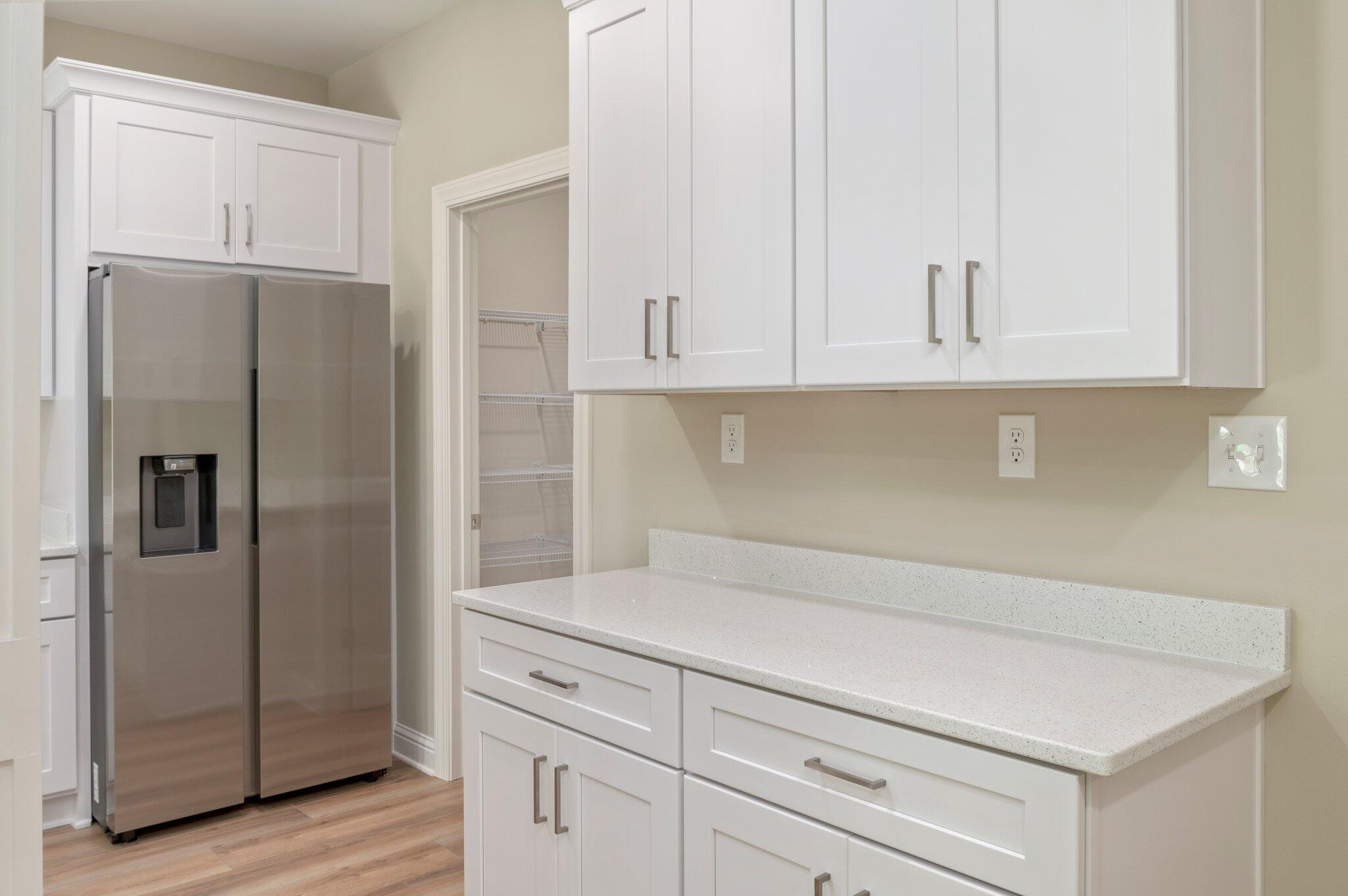 6043 Sand Hill Road Crestview, FL 32539 - Photo 16 of 36 a kitchen with cabinets and a refrigerator