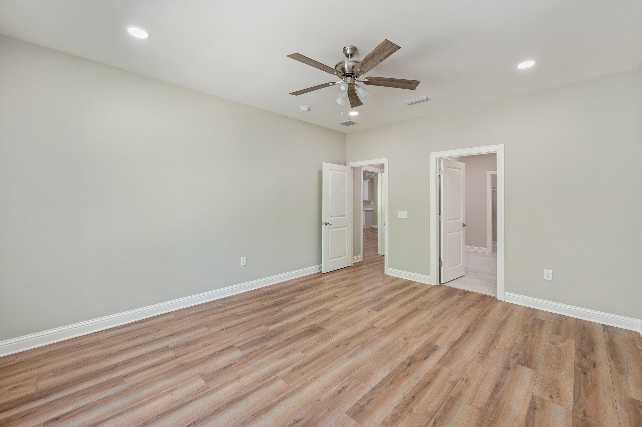 6043 Sand Hill Road Crestview, FL 32539 - Photo 19 of 36 an empty room with wooden floor and windows