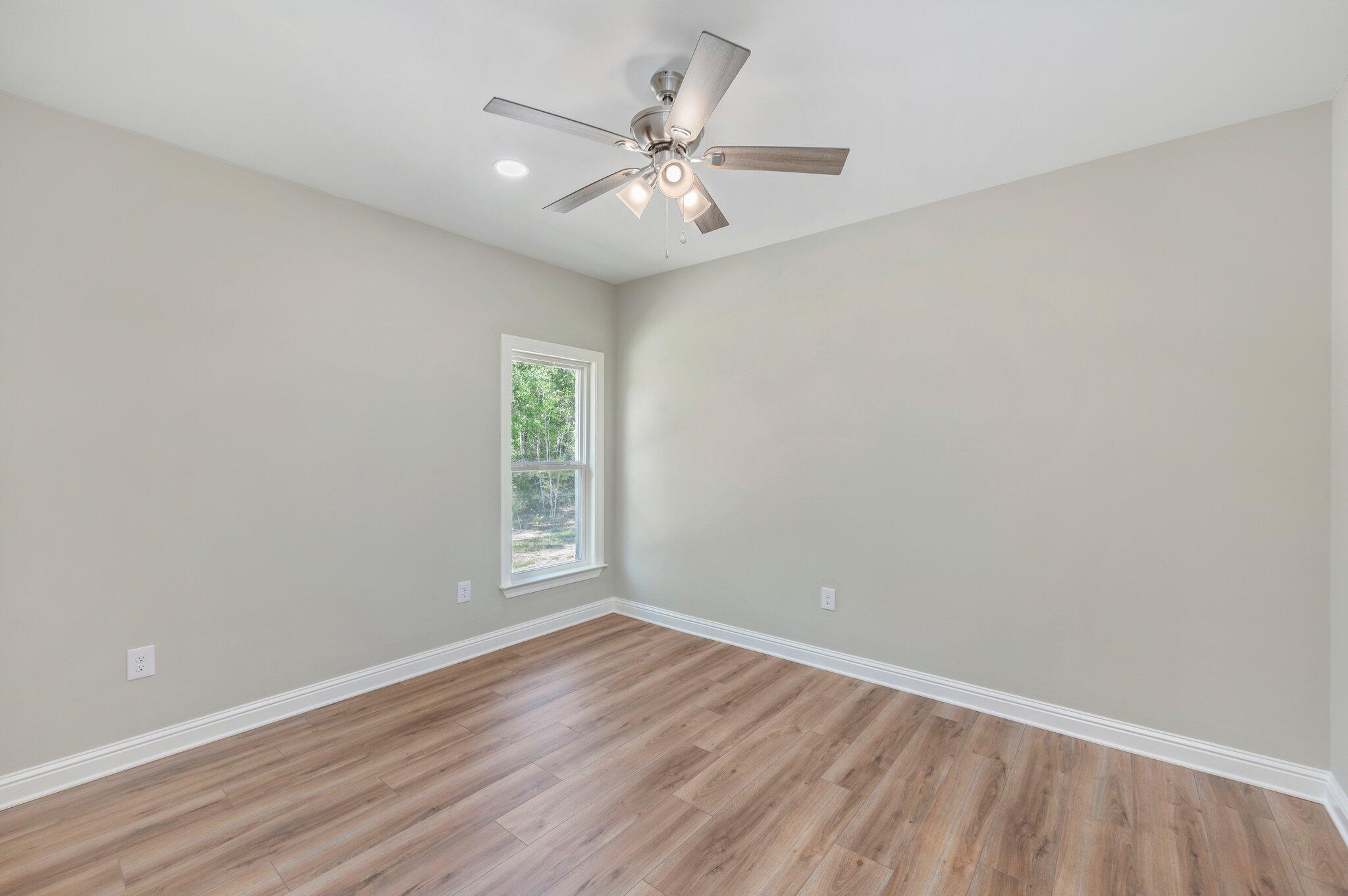6043 Sand Hill Road Crestview, FL 32539 - Photo 27 of 36 wooden floor in an empty room with a window