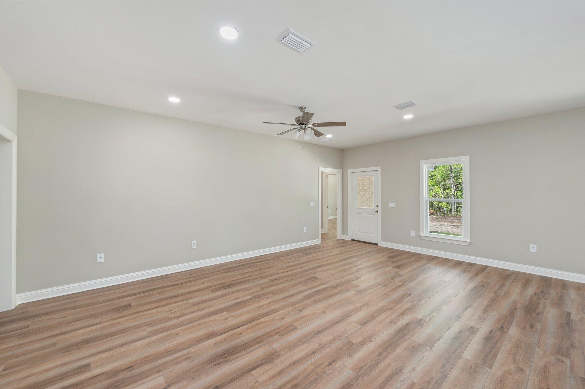 6043 Sand Hill Road Crestview, FL 32539 - Photo 7 of 36 wooden floor in an empty room with a window