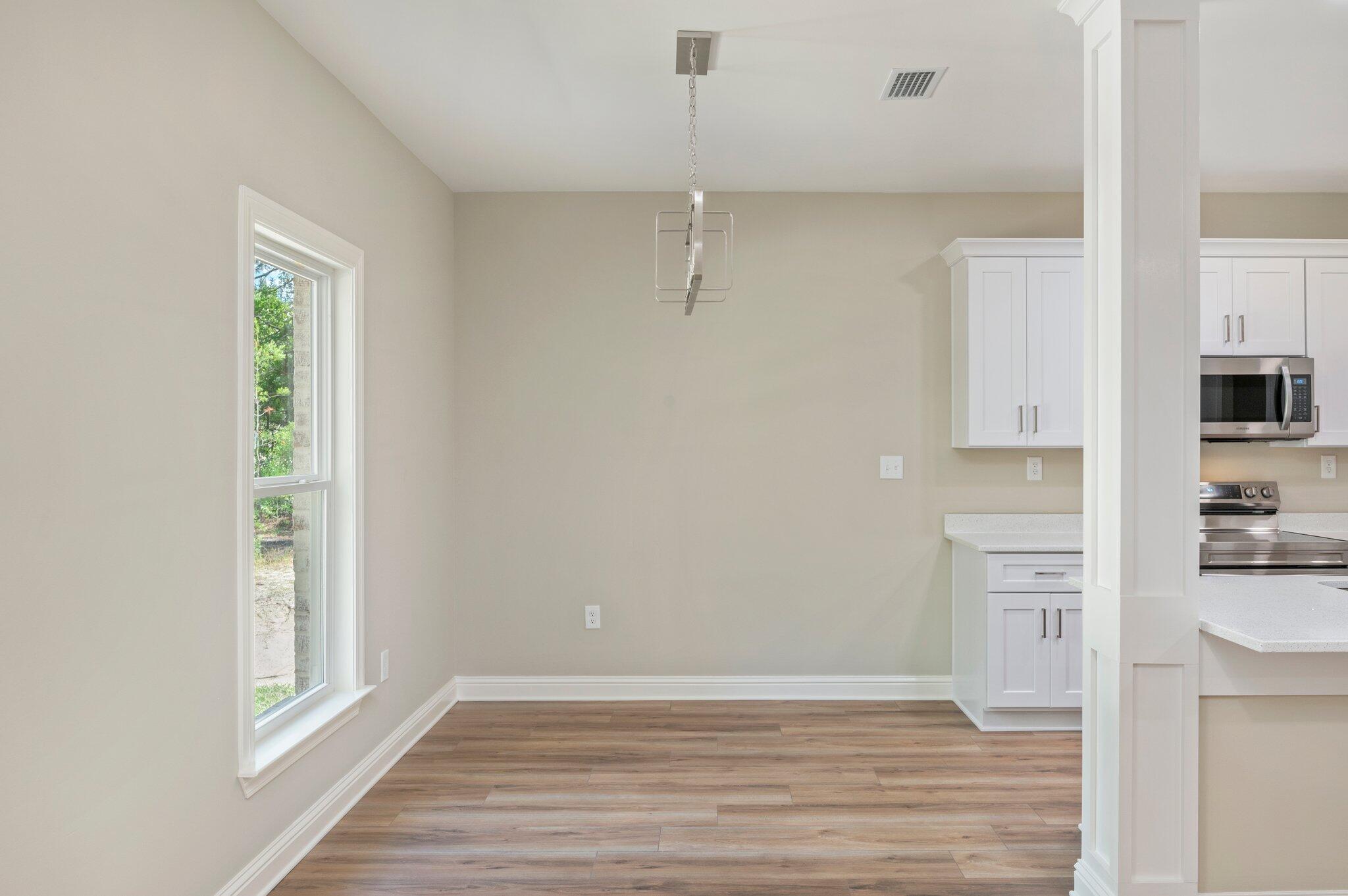 6043 Sand Hill Road Crestview, FL 32539 - Photo 10 of 36 a view of a kitchen with wooden floor and a window