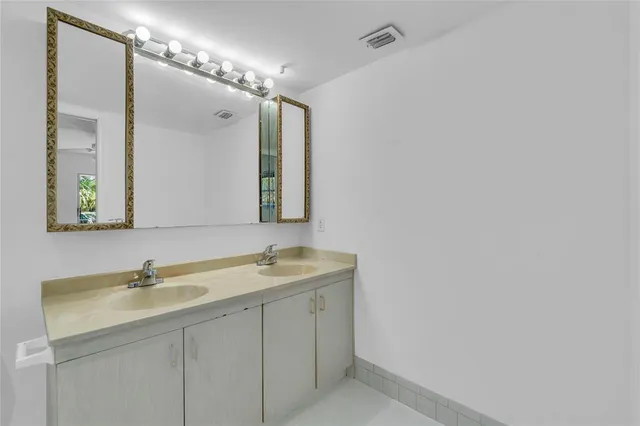 a bathroom with a double vanity sink and a mirror