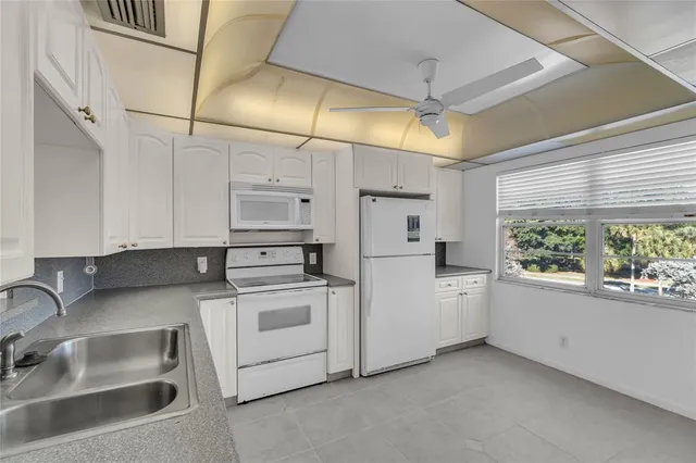 a kitchen with white cabinets and white appliances