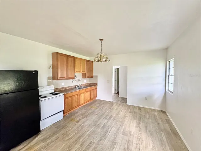 a view of a kitchen counter space a sink wooden floor and a window