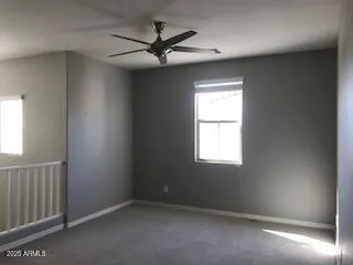 an empty room with a window and a fan