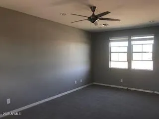 an empty room with a window and a fan