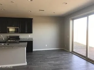 a kitchen with stainless steel appliances granite countertop a stove a sink and a microwave