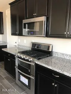 a kitchen with granite countertop a stove and a microwave