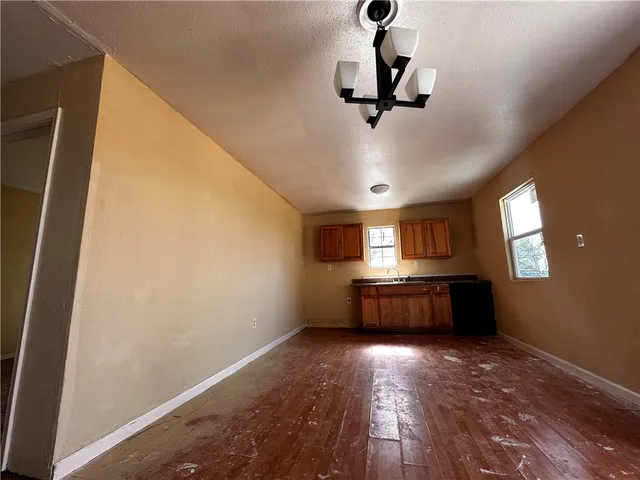 a room with a chandelier and wooden floor