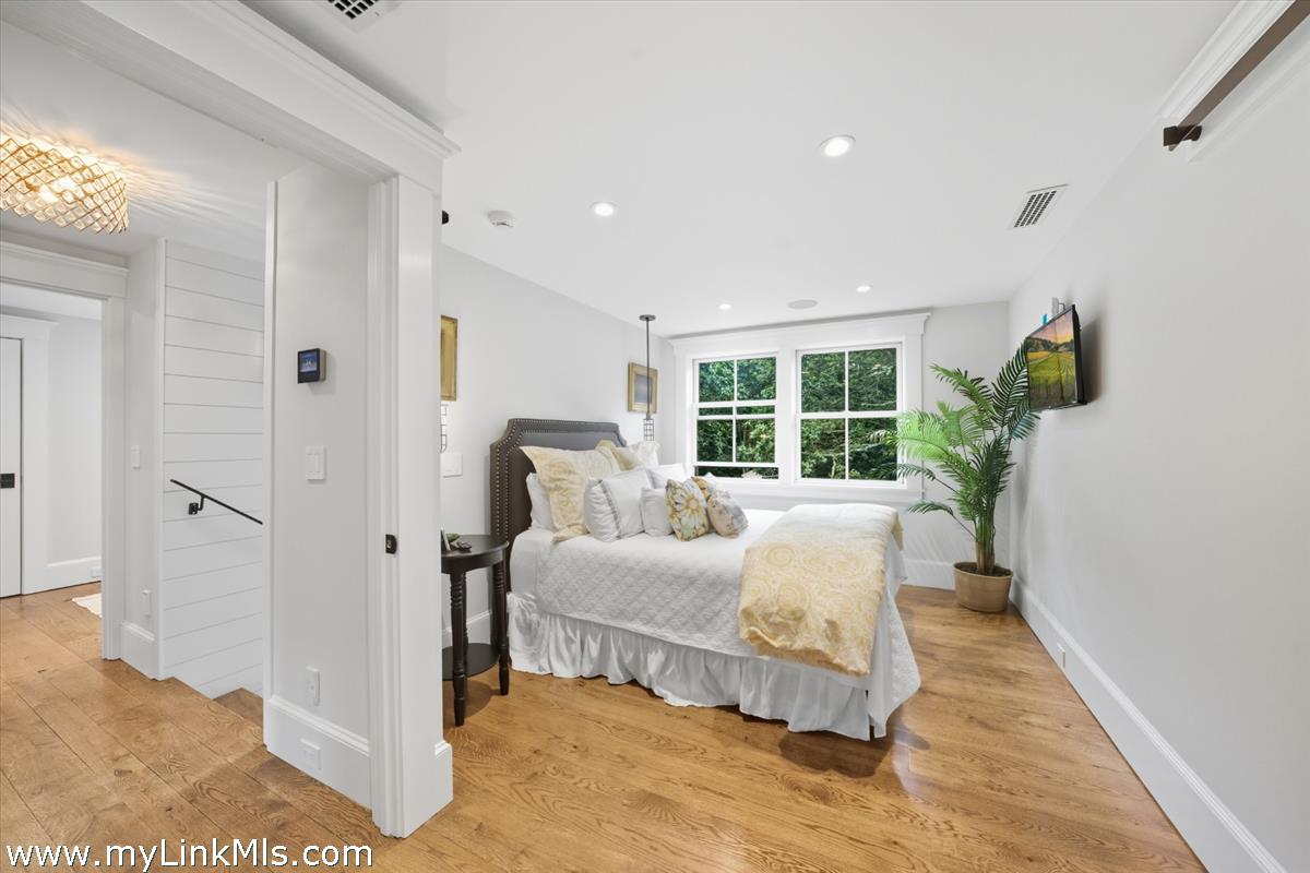 27 Clambelly Road Chilmark, MA 02535 - Photo 25 of 39 a bedroom with a bed and wooden floor