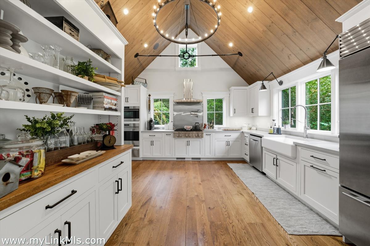 27 Clambelly Road Chilmark, MA 02535 - Photo 10 of 39 a large kitchen with stainless steel appliances granite countertop a large stove a sink dishwasher and white cabinets with wooden floor
