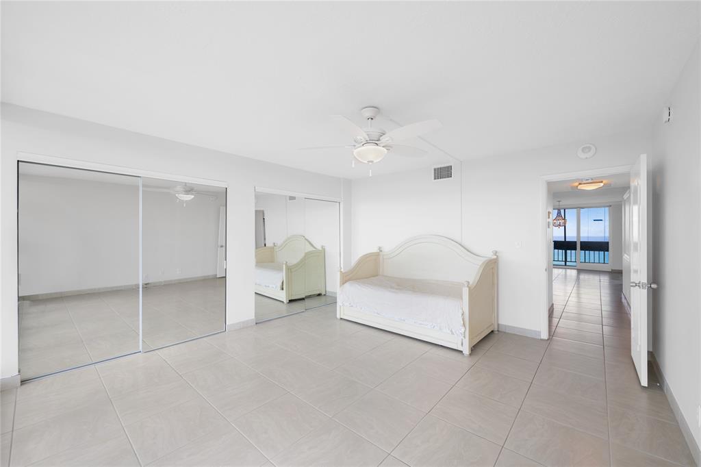 4280 Galt Ocean Drive, Unit 25C Fort Lauderdale, FL 33308 - Photo 19 of 55 a spacious bedroom with a bed and a chandelier