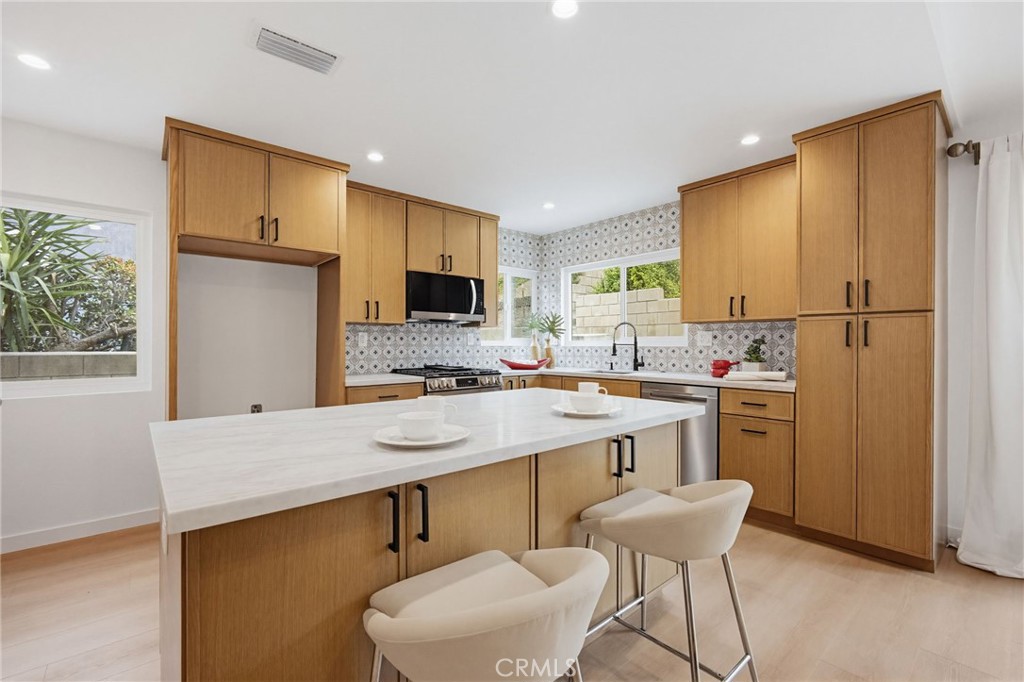 7355 Vineyard Avenue Rancho Cucamonga, CA 91730 - Photo 11 of 38 a kitchen with a refrigerator a sink and chairs