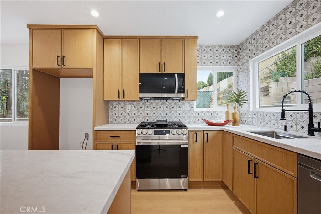 7355 Vineyard Avenue Rancho Cucamonga, CA 91730 - Photo 3 of 38 a kitchen with a stove a sink and a microwave