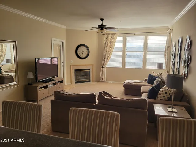 a living room with furniture a flat screen tv and a window