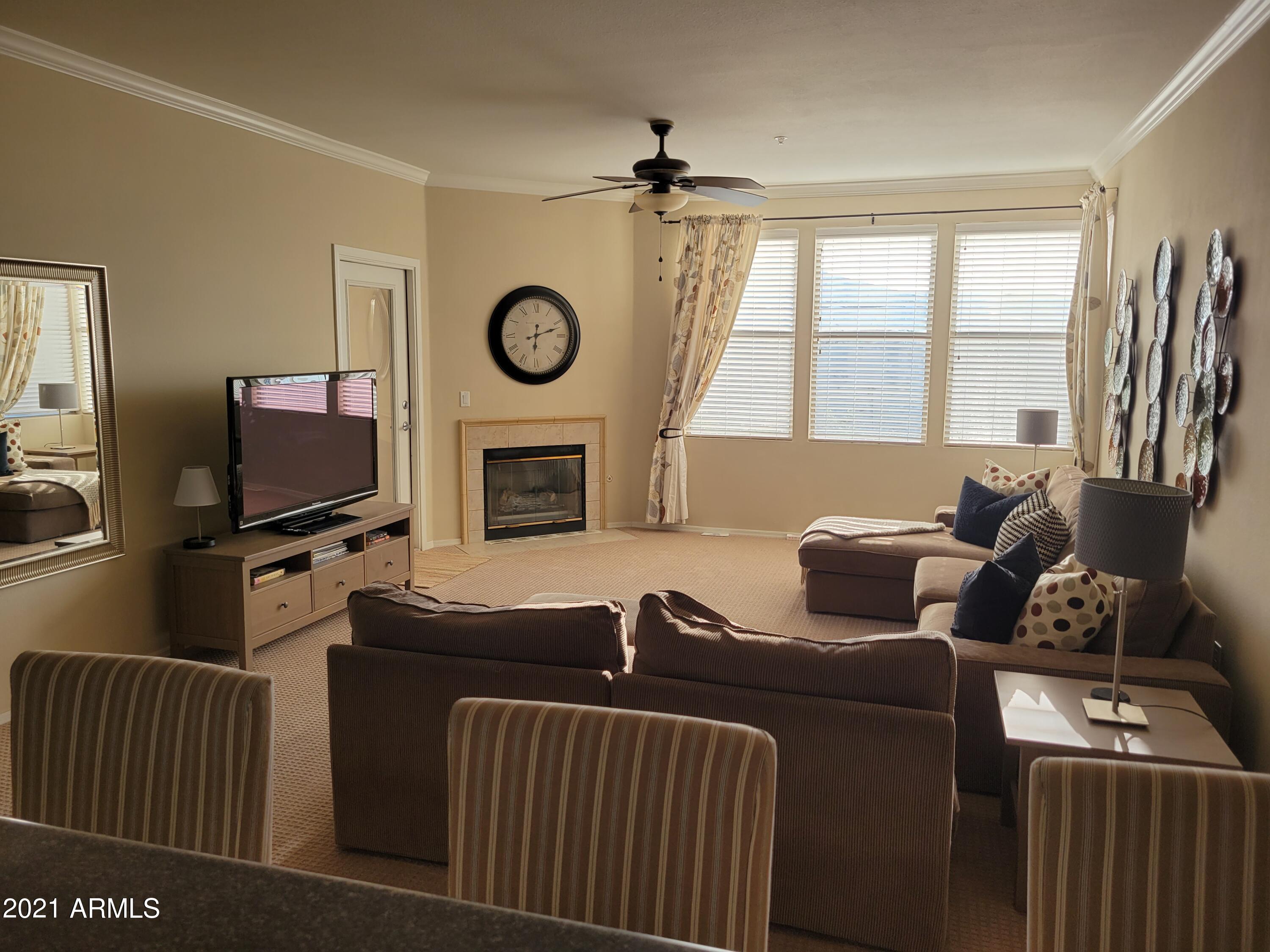 a living room with furniture a flat screen tv and a window