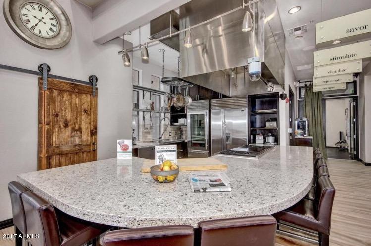 19777 North 76th Street, Unit 3186 Scottsdale, AZ 85255 - Photo 12 of 23 a kitchen with stainless steel appliances granite countertop a sink a stove and chairs