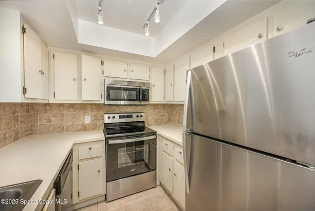 a kitchen with stainless steel appliances a refrigerator sink and microwave
