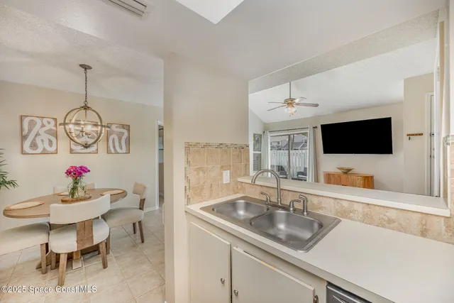 a kitchen with a sink and a flat screen tv