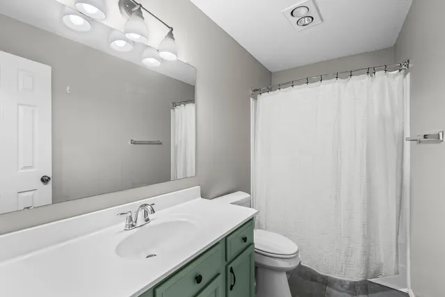 a bathroom with a sink vanity mirror and toilet