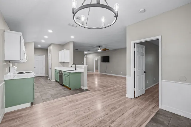 a large kitchen with stainless steel appliances kitchen island granite countertop a stove a sink and a wooden floors