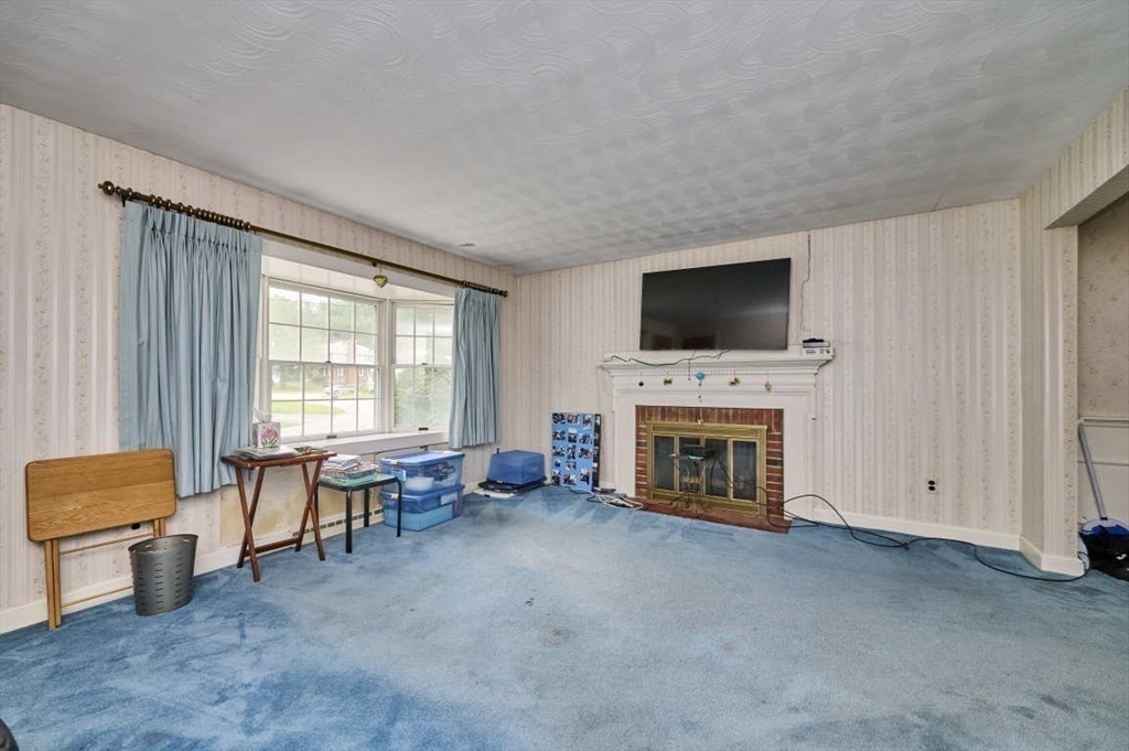 9 Bowman Road Billerica, MA 01821 - Photo 9 of 23 a living room with furniture a fireplace and a flat screen tv