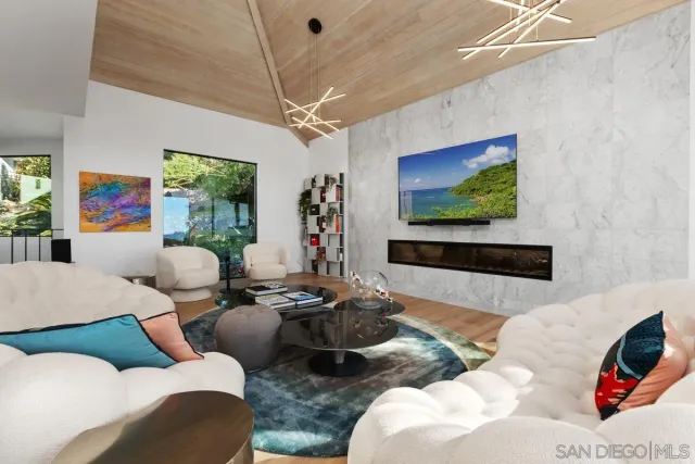 a living room with furniture a flat screen tv and a chandelier