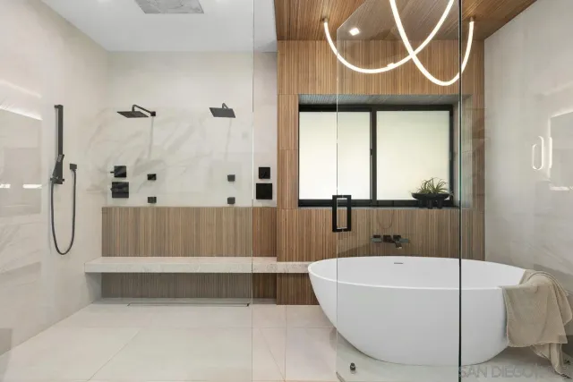 a bathroom with a bathtub a window and a shower