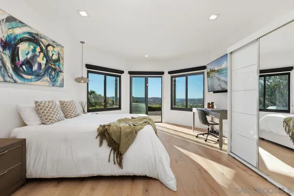 a spacious bedroom with a large bed and a painting on the wall