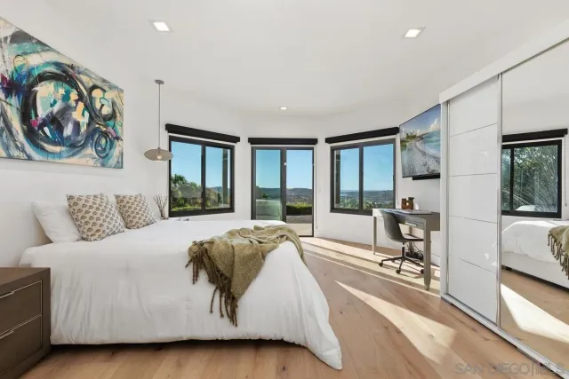 a spacious bedroom with a large bed and a painting on the wall