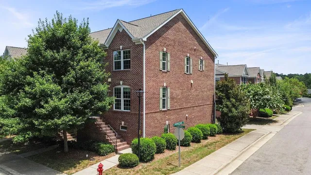 a front view of a house with plants and trees